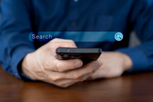 Close-up of hand a man using a mobile phone search for information interest on search engine website