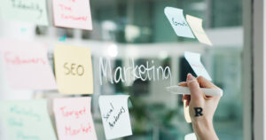 Marketing campaign planning session with SEO, target market, and strategy notes on a glass board